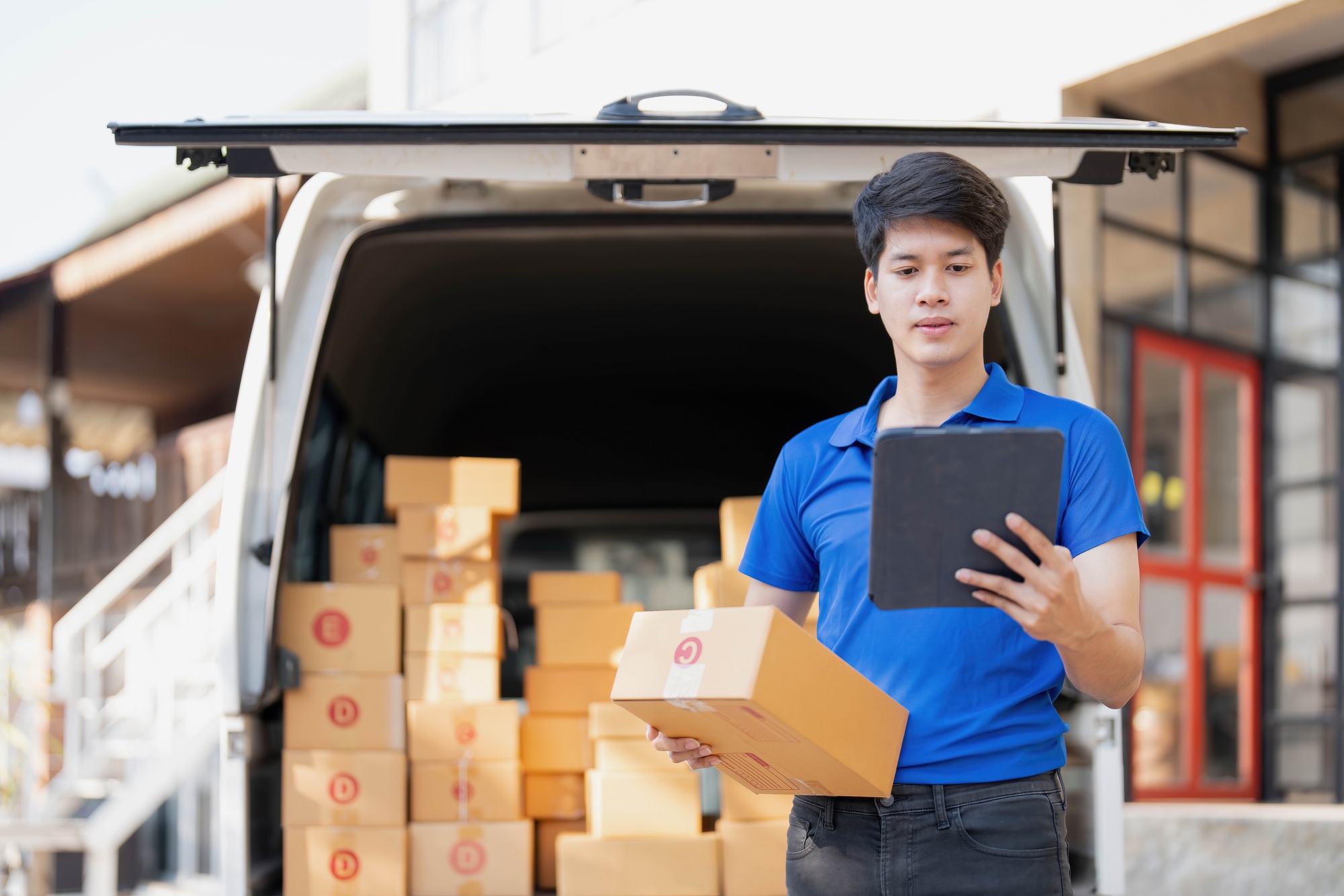 Asian courier with parcel and delivery logistic concept. Delivery man with checking list on